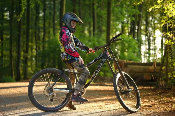 Junger Biker mit Bike im Grünen
