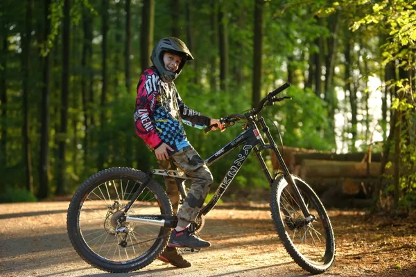 Junger Biker mit Fullface-Helm und Bike