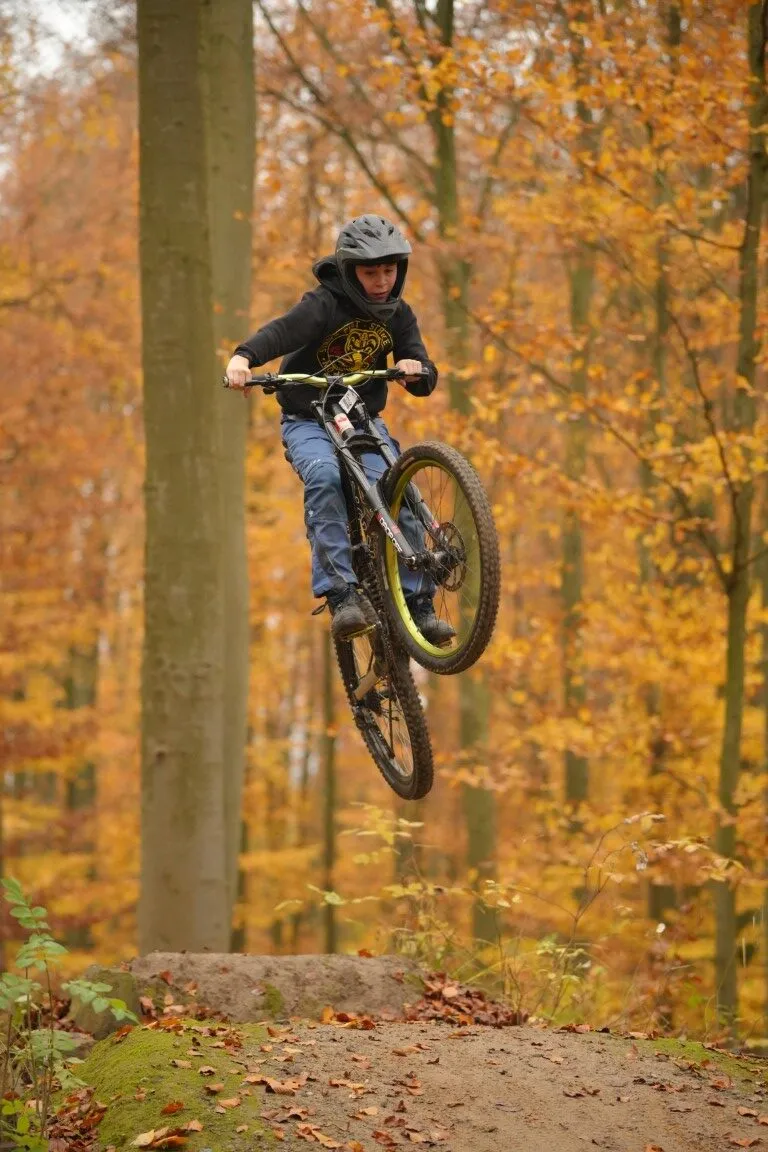 Biker springt über einen Kicker im Wald